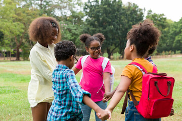 Group of African American children joining their hands in the park. Diverse black children joining their hands. Successful and teamwork concept