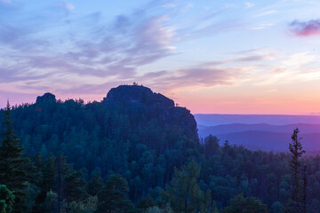 Smoky silhouette of cliff and mountains in beautiful sunset light in retrowave style