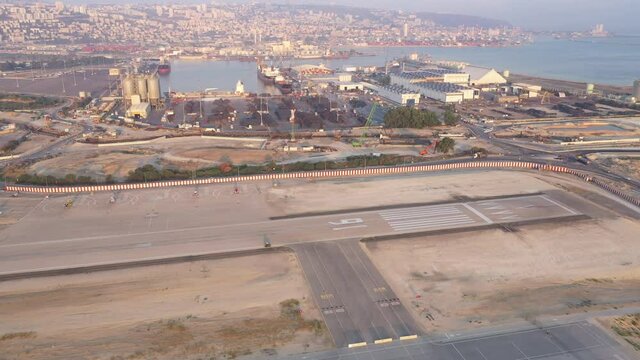 Haifa airport and runway with the city skyline in the background, Aerial view.