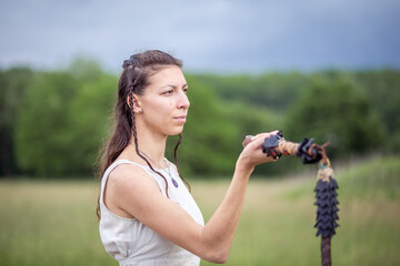 Close up of A woman in a linen dress with a whip