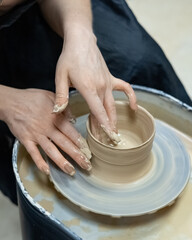 a worker makes a clay product on a potter's wheel
