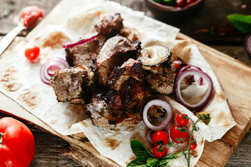 Grilled meat with vegetables on pita bread. Shashlik
