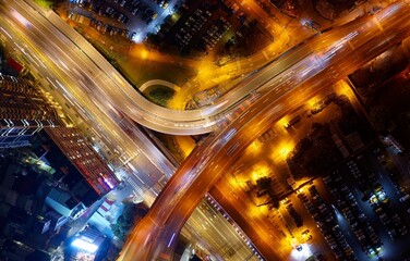 Fototapeta na wymiar Vertical top down view above the elevated access road of Zhongzheng Bridge & Huanhe Expressway at night, with light trails of cars dashing on the highways, in Yonghe District, New Taipei City, Taiwan