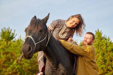 Obraz premium A rural couple with a horse in a natural yellow landscape on an autumn day. Young man and woman together with an animal