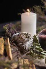 white candle sage and herbs