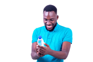 handsome young man looking at bottle of mineral water smiling.