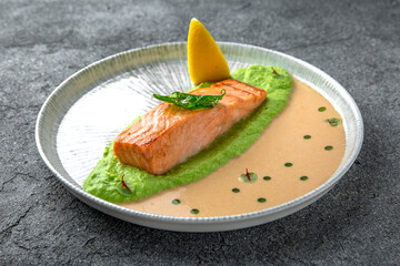 Salmon fillet on spinach avocado puree with shrimp sauce. Ready menu for the restaurant. Neutral gray blue textured background