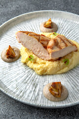 Grilled chicken fillet with mashed potatoes and fried mushrooms. Ready menu for the restaurant. Neutral gray blue textured background