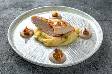 Grilled chicken fillet with mashed potatoes and fried mushrooms. Ready menu for the restaurant. Neutral gray blue textured background