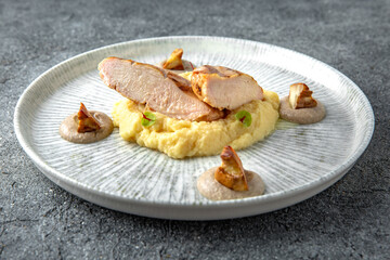 Grilled chicken fillet with mashed potatoes and fried mushrooms. Ready menu for the restaurant. Neutral gray blue textured background
