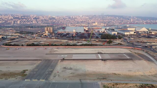 Haifa airport and runway with the city skyline in the background, Aerial view.