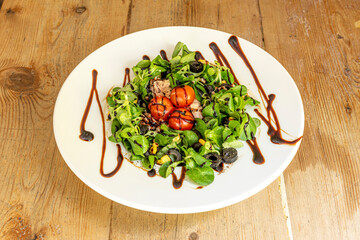 Delicious canned bonito salad with lamb's lettuce, black olives, sweet corn, cherry tomatoes and balsamic vinegar
