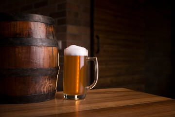Glass of light beer on a dark pub.