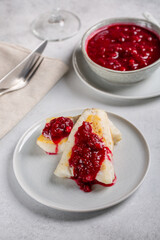 Roasted white fish fillet served with red cranberry sauce on gray plate  on concrete background.