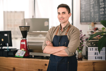 Male barista working at a coffee shop ready to order