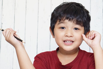 Cute Asian child little Thai boy 4 year old smile make a happy face concept.