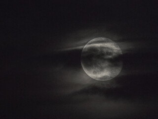 the mysterious moon is hidden behind a thin veil of clouds