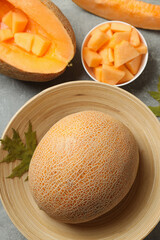 Concept of fresh food with melon on gray textured table