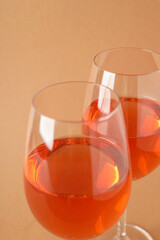 Glasses of wine on beige background, close up