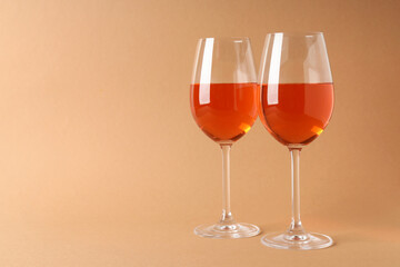 Glasses of wine on beige background, space for text