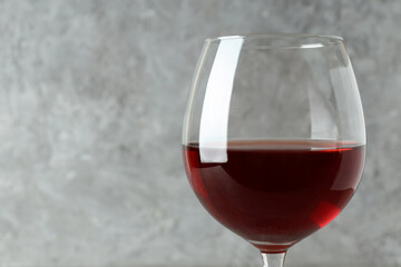 Glass of red wine on gray textured background