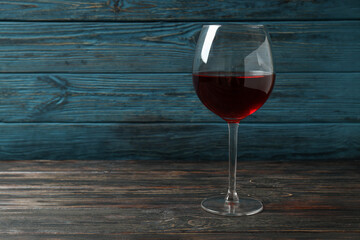Glass of red wine on rustic wooden background