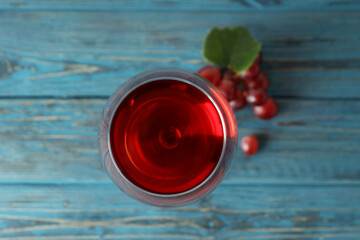 Glass of red wine and grape on wooden table
