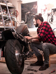 Fototapeta na wymiar Motorradfahrer repariert sein Motorrad, Garage, Schrauber, Mechaniker, 