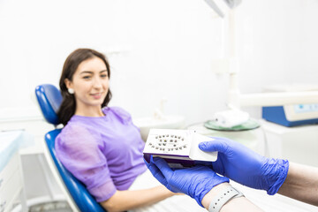 Dentistry concept. Professional dental services and modern equipment without pain. The doctor demonstrates the veneers for installation to the patient