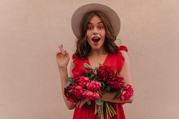 Close portrait of young italian girl surprised about fresh peonies from her husband. Brunette...