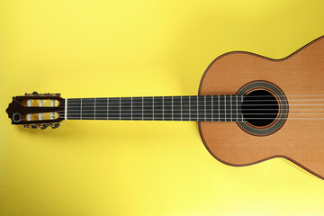 Fototapeta na wymiar Classical guitar on yellow background, top view