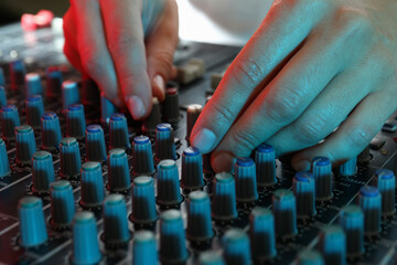 The musician adjusts the sound on audio mixer