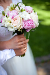 Bridal bouquet of peonies and roses. Hold wedding flowers in your hands