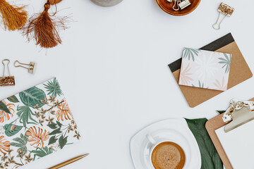 Flat lay Blogger workspace. Home office desk with tropical monstera leaf, cup of coffee, supplies,  notebook and pen. Flat lay, top view, copy space - 455679264