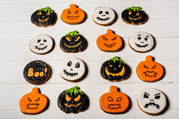 high angle view of homemade and spooky halloween cookies on white surface
