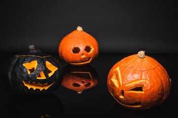 carved orange and black pumpkins on dark background
