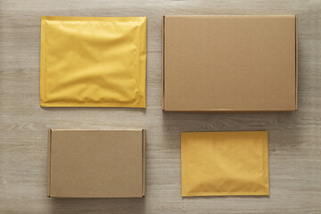 Top view of set different sizes of boxes and padded envelopes on the wooden table.Send and receive...