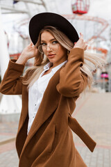 Walking around the city, cute girl smiling, wearing a coat, raincoat and felt hat, autumn mood, autumn-winter season