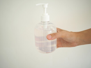 woman holding a bottle of alcohol gel on white background. concept of disease prevention.