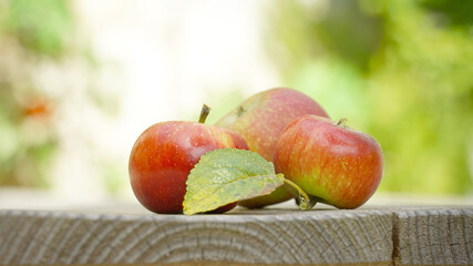 three apples in the garden on a wooden table background