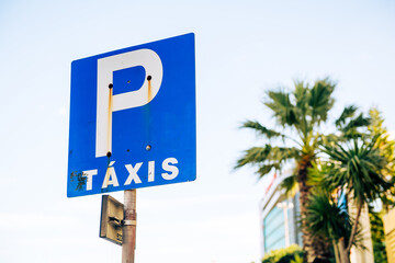 Taxis sign translated as taxi with palm tree in background on the streets of Lisbon, Portugal