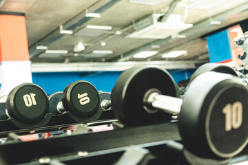 Fototapeta na wymiar Dumbbells in the interior of the gym without people