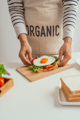 male hands preparing egg sandwich at kitchen