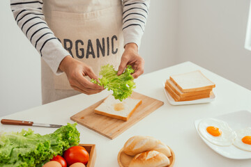 male hands preparing an open sandwich with vegetables