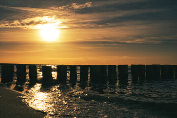sunset in Zingst at the sea. red orange sun sets on the horizon. Seagulls circle in the sky
