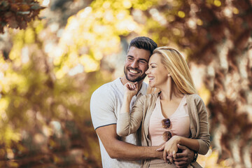 Smiling couple having fun in autumn park