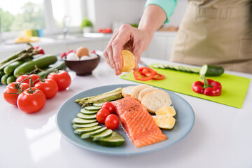 Photo of mature woman squeeze lemon juice dish cook gourmet salmon vegetables diet cafe delicious...