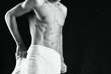 a man with a pumped-up body covers himself with a towel studio fitness
