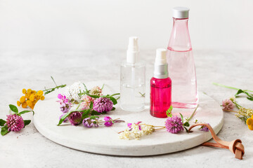 Fototapeta na wymiar bottles skincare lotion serum medical flowers herbs. natural cosmetic. clover milfoil tansy rosebay