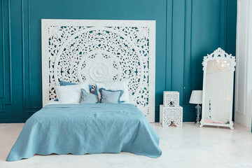 Beautiful luxury classic clean interior bedroom in white and deep blue color with king-size bed and...